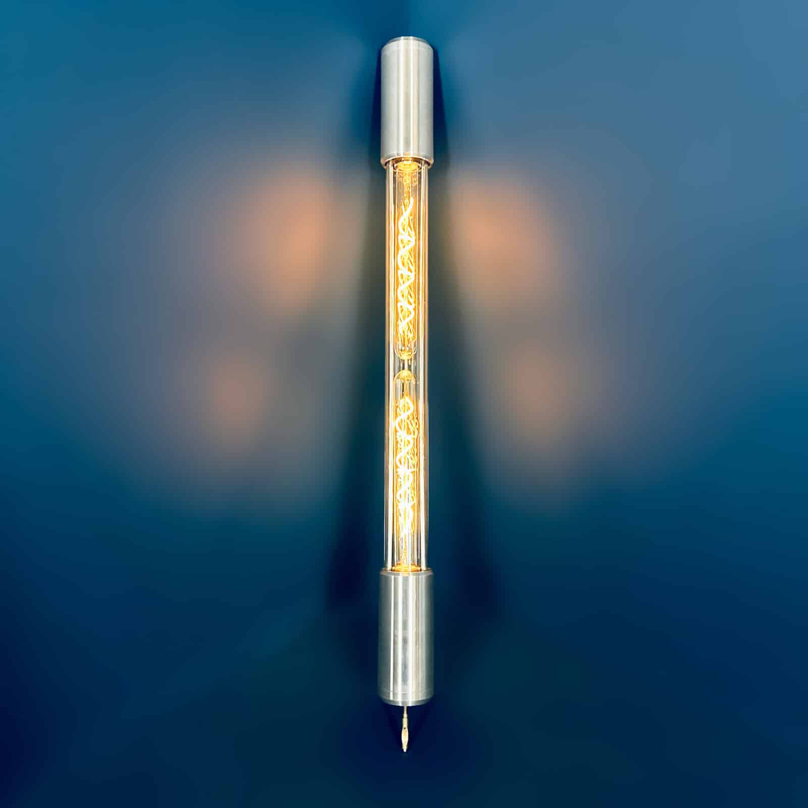Industrial style tube floor lamp made from machined aluminium and glass and fitted with two edison LED filament tubes - making this design fuse both form and function. It is a leaning tube floor lamp which elegantly stands on a point to illuminate corners and walls from the floor.