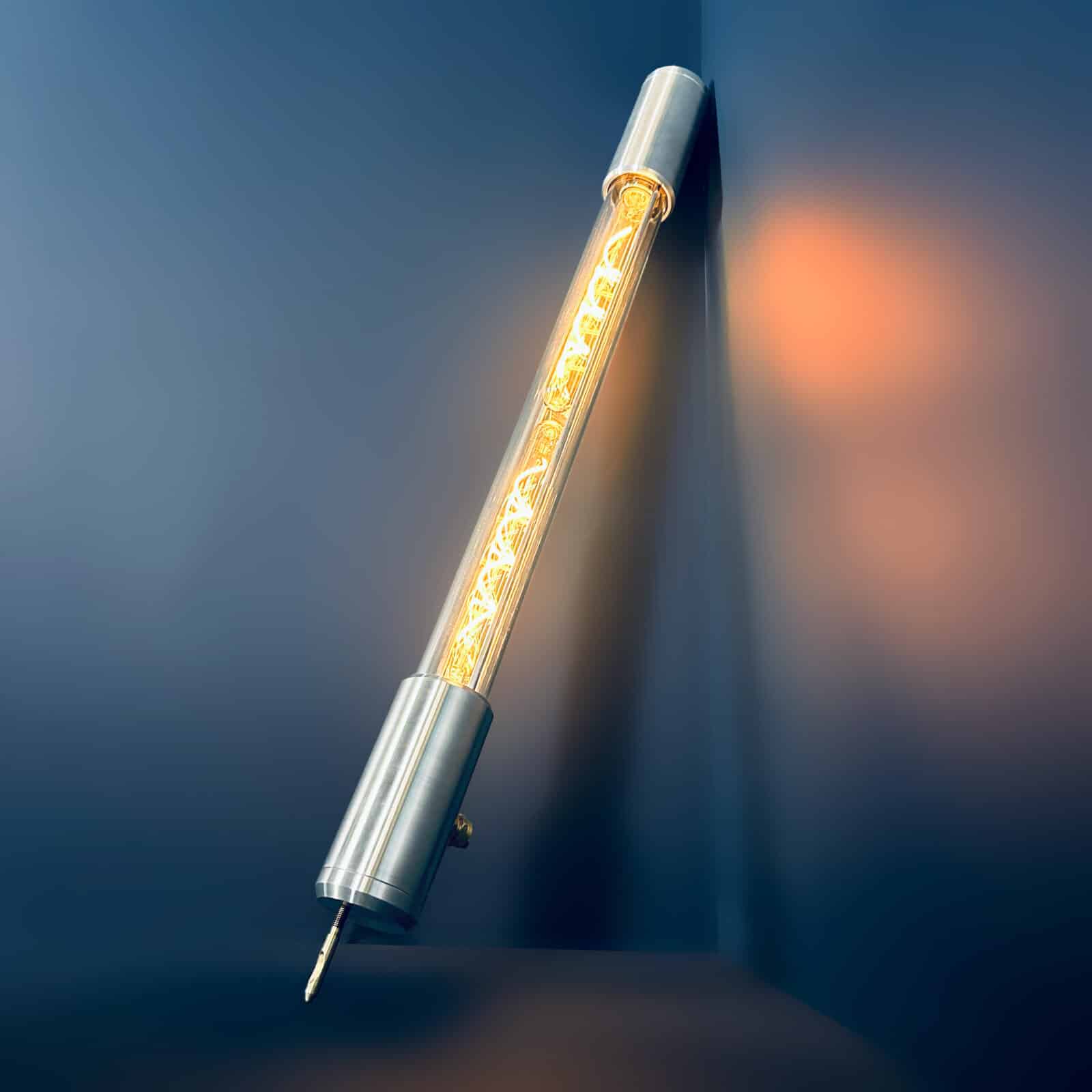 Industrial style tube floor lamp made from machined aluminium and glass and fitted with two edison LED filament tubes - making this design fuse both form and function. It is a leaning tube floor lamp which elegantly stands on a point to illuminate corners and walls from the floor.