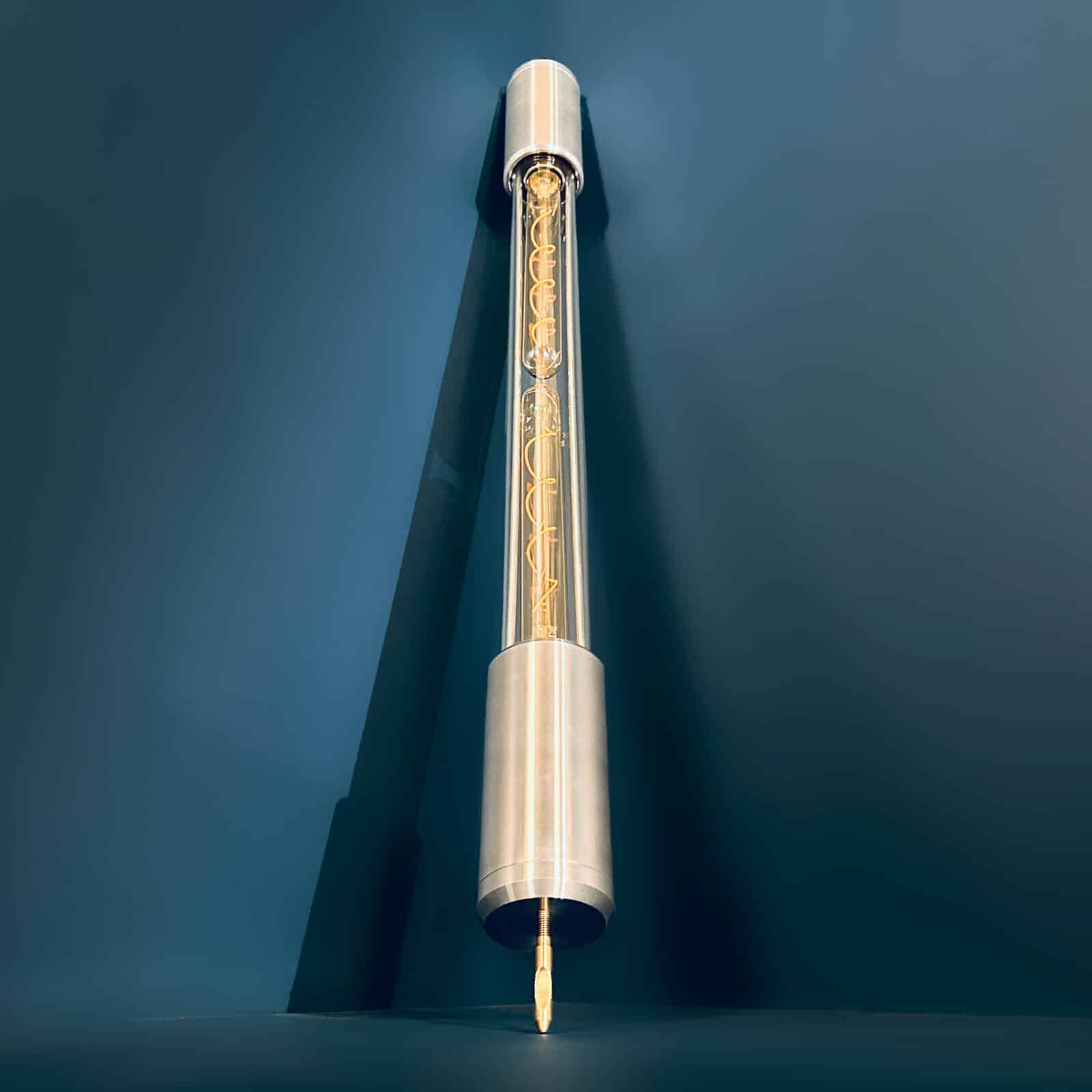 Industrial style tube floor lamp made from machined aluminium and glass and fitted with two edison LED filament tubes - making this design fuse both form and function. It is a leaning tube floor lamp which elegantly stands on a point to illuminate corners and walls from the floor.