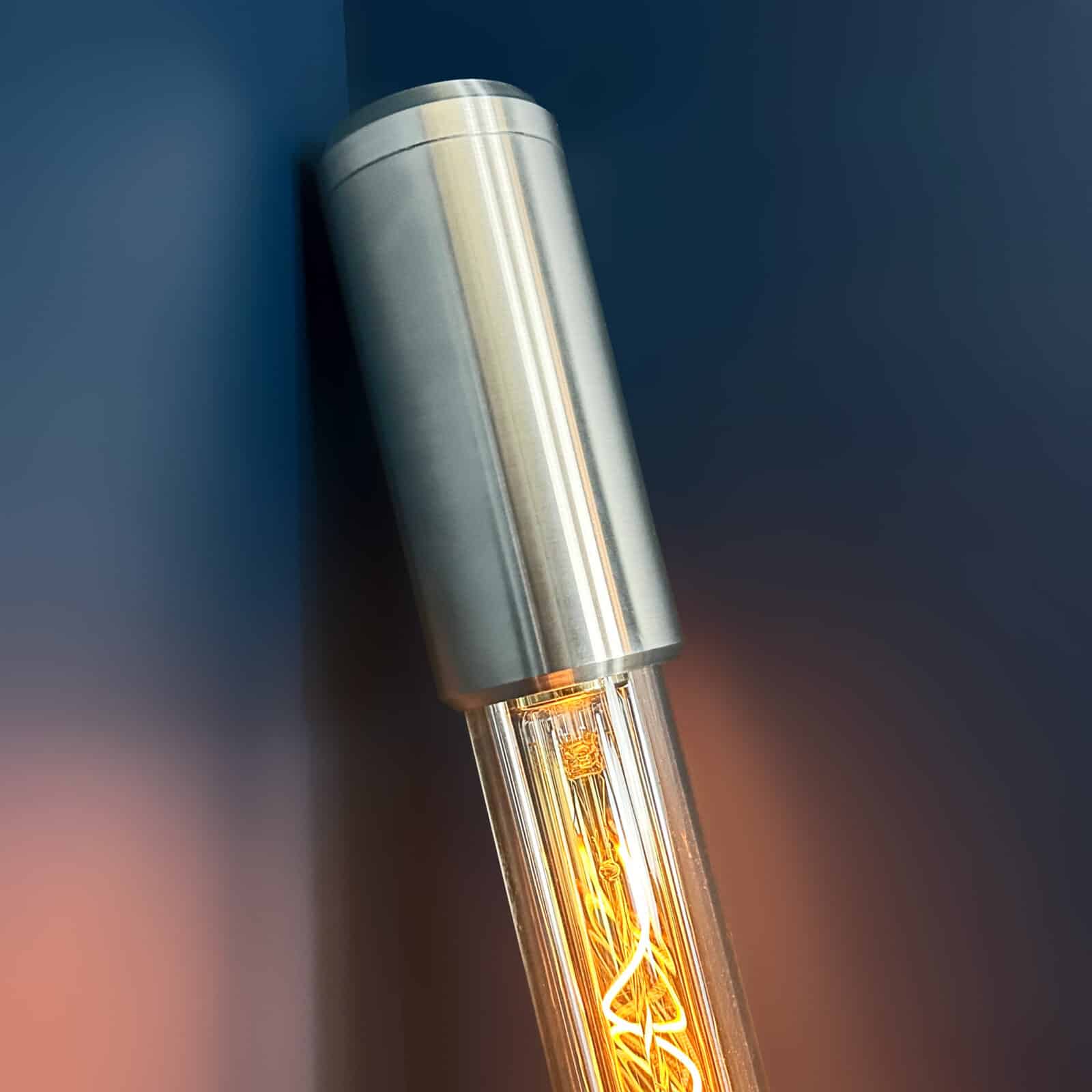 Industrial style tube floor lamp made from machined aluminium and glass and fitted with two edison LED filament tubes - making this design fuse both form and function. It is a leaning tube floor lamp which elegantly stands on a point to illuminate corners and walls from the floor.